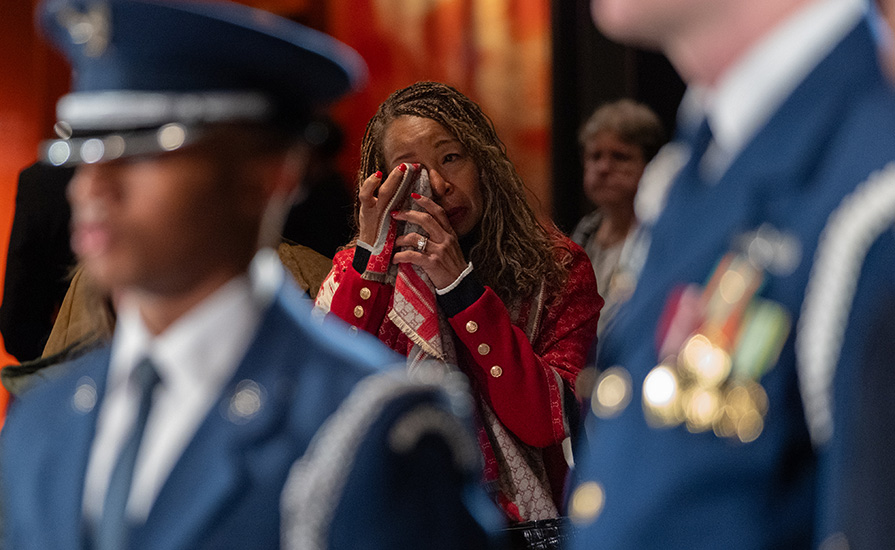 A woman wipes away tears.